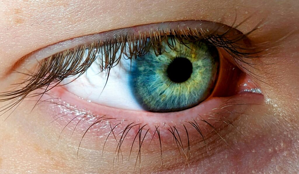 Can Eye Exercises Improve Astigmatism? Detailed macro shot of a blue-green human eye showcasing intricate details of the iris.